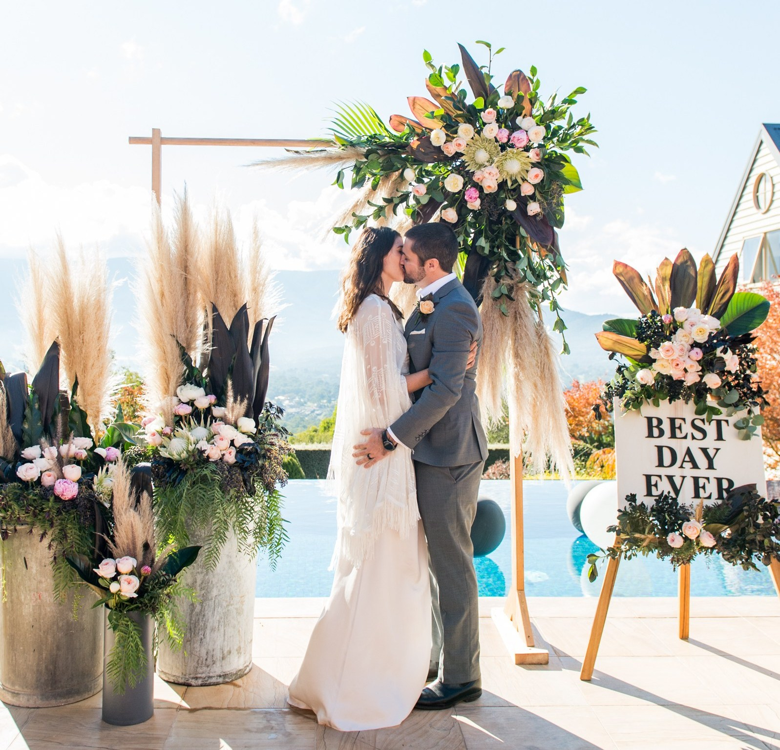 The bridegroom share a kiss under the beautifully adorned arch