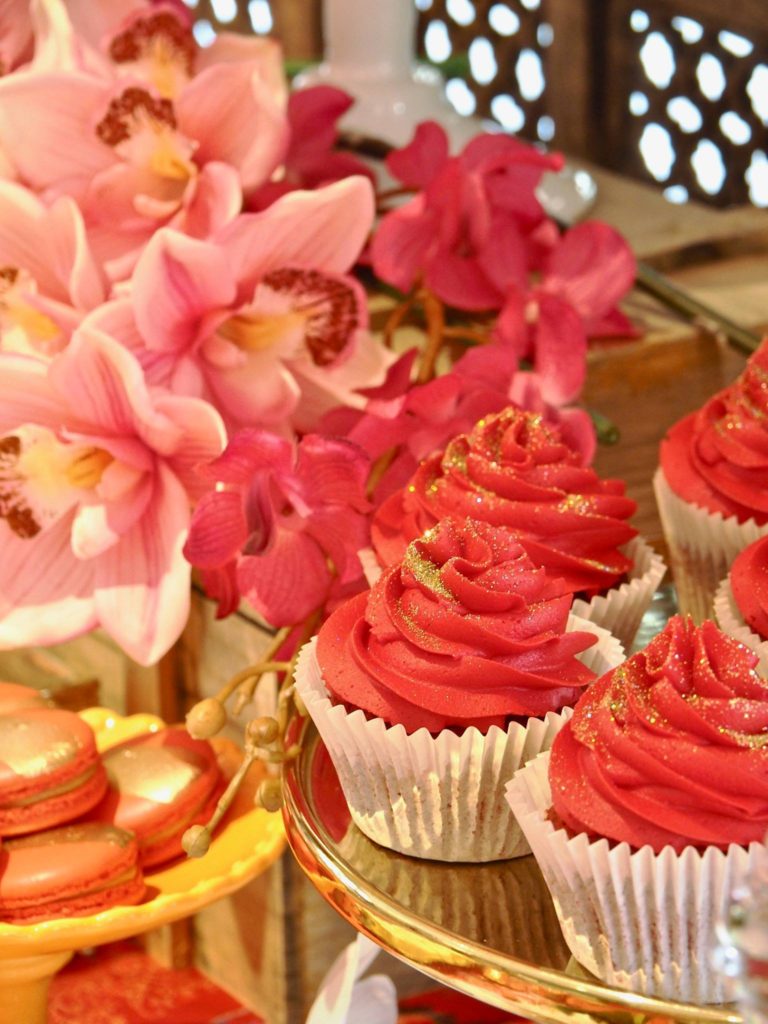 Red cupcakes on a Singaporean themed dessert bar.